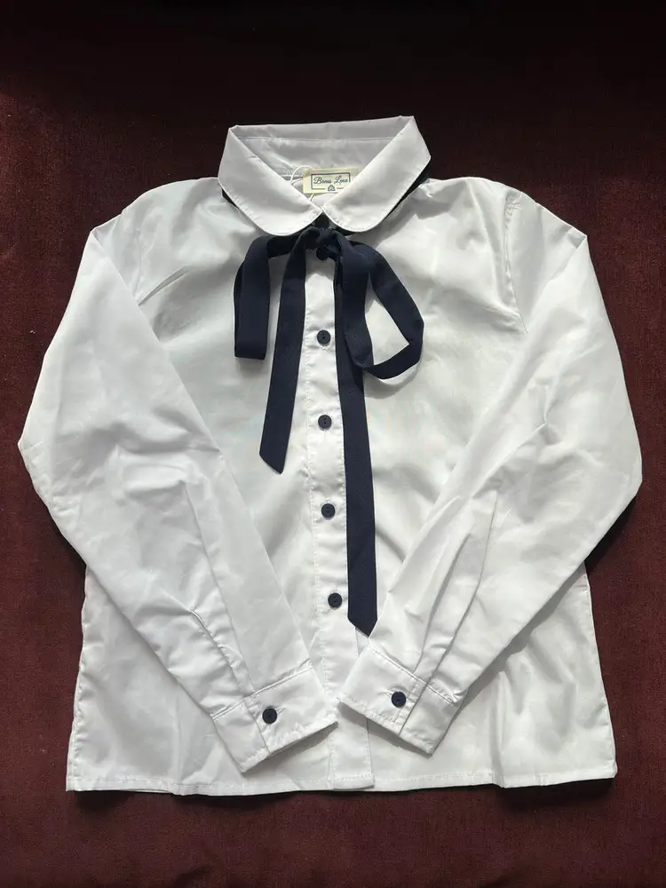 Заказывала несколько блузок для школы на сменку (у нас обязательная форма), оставила в итоге эту, хоть она и была дороже всех. Во-первых бант - изюминка, и хорошо что снимается - можно и стирать спокойно и любой другой бант повесить - универсальная рубашка и в школу и на праздник. Во-вторых - состав ткани (да простят меня любители 100% хлопка, но по моему опыту в школьной одежде смесовый хлопок гораздо проще в уходе при том же комфорте для тела. Ведь форму постоянно нужно стирать и гладить! И в третьих - отличное качество пошива (все строчки ровные, внутренние швы закрытые - такое вообще редко бывает в одежде масс сегмента).  Доставили за два дня, упакована хорошо, размер подошёл. Спасибо ВБ и продавцу!