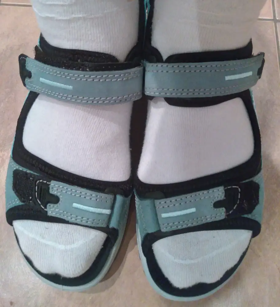 Прежде, чем купить эти сандалии, я внимательно прочитала все отзывы. Уяснила, что модель маломерка, на узкую ногу. Поскольку у меня размер ноги 35 (22,5), я решила, что мне как раз всё подойдет - даже если сандалии окажутся великоваты, не страшно, я все равно собираюсь их носить на носки, а ширину отрегулирую ремешками. Сандалии и правда сели на мне, как влитые. Но! Почему-то никто не написал, что отрегулировать ширину ремешками не получится. Под ремешками в области пальцев находится ткань, она практически не тянется. На фото видно, что ремешки я застегнула до половины, и все равно пальцам тесно, хотя полнота у меня 6 (F), т.е. стандарт, зато есть косточки. И эти косточки я сразу натерла. Завтра понесу в мастерскую, может, удастся решить проблему. Это даже не смешно - дорогущую обувь раскрученного бренда должен доводить "до ума" мастер с копеечной зарплатой. Почему производитель сам не мог догадаться сделать ремешки в области пальцев более эластичными? Эта область у многих проблемная.