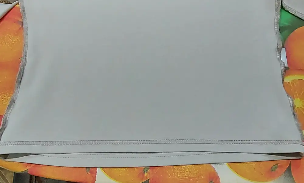 Очень короткий. По спинке короче переда на 1 см. Сплошная синтетика