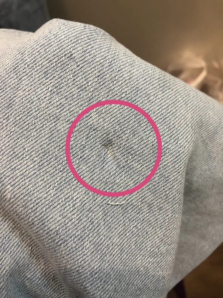Неровный шов на одной джинсе, очень сильно выпирает на переднюю поверхность, есть дефект на ткани с пятном и большая дыра в области кармана